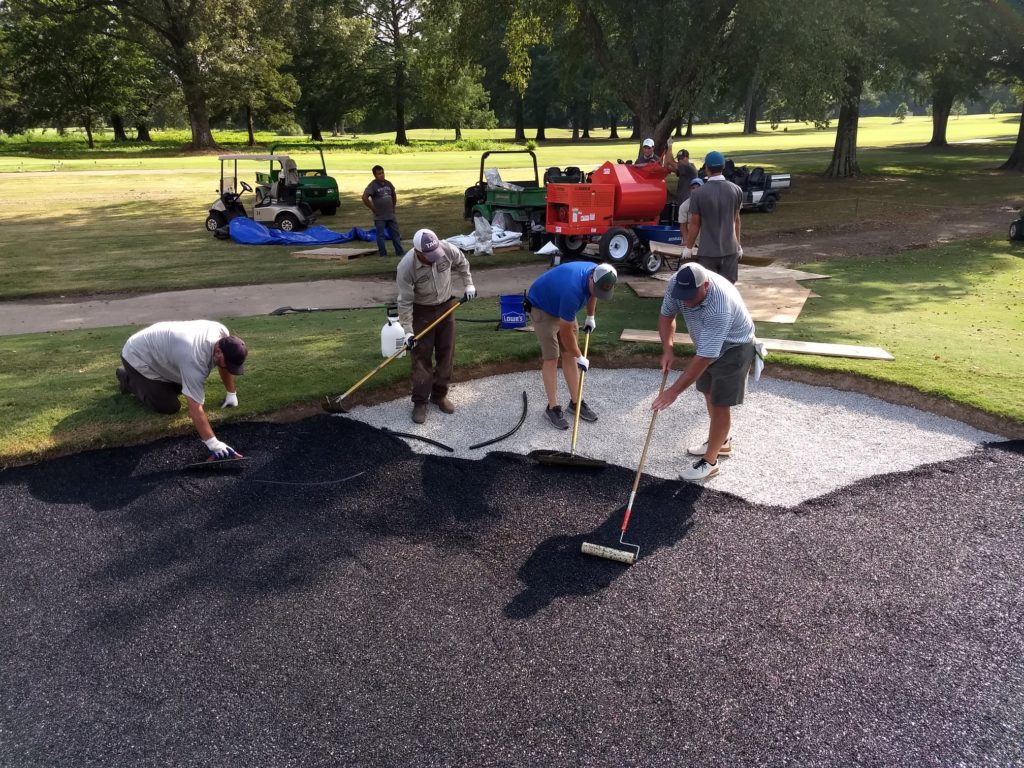 Men installing a rubber golf bunker liner